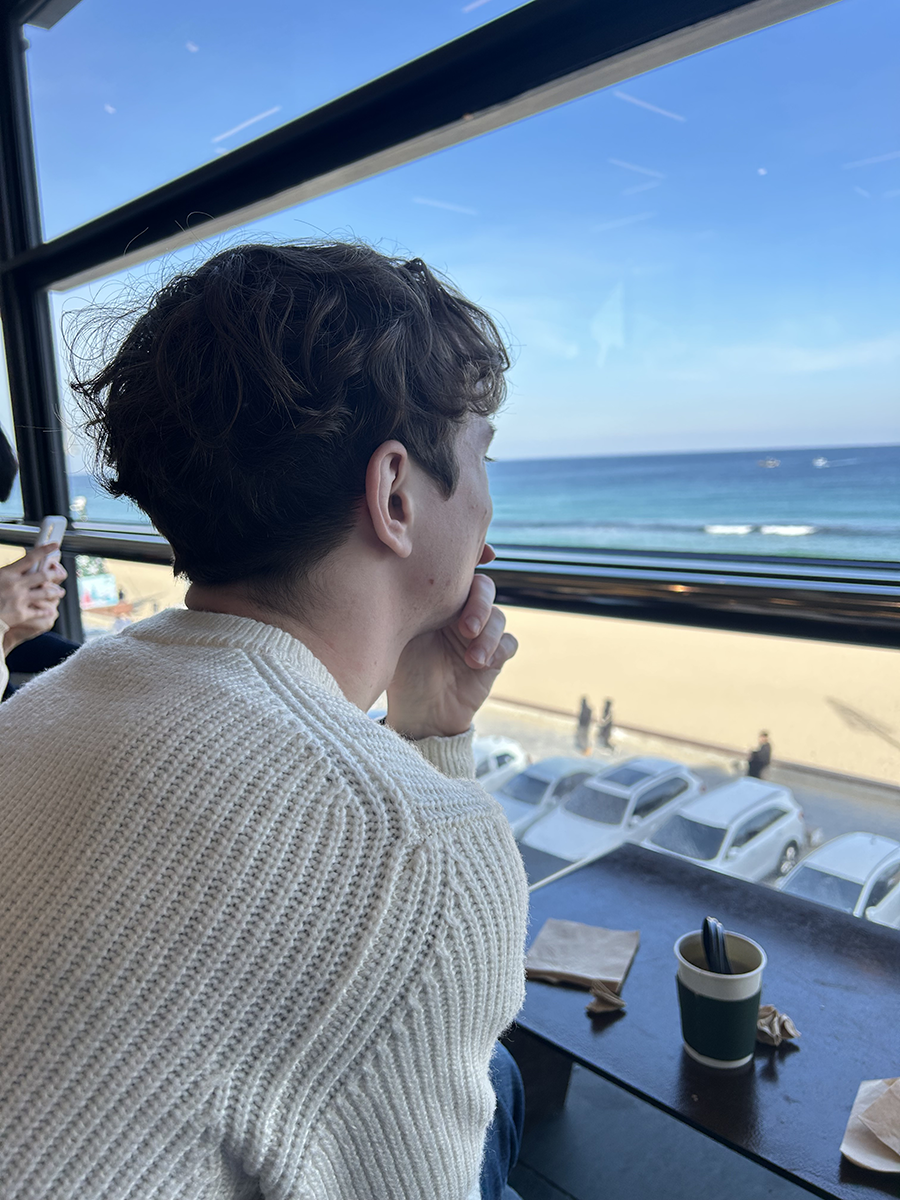 Photo of Camden at a cafe looking out the window