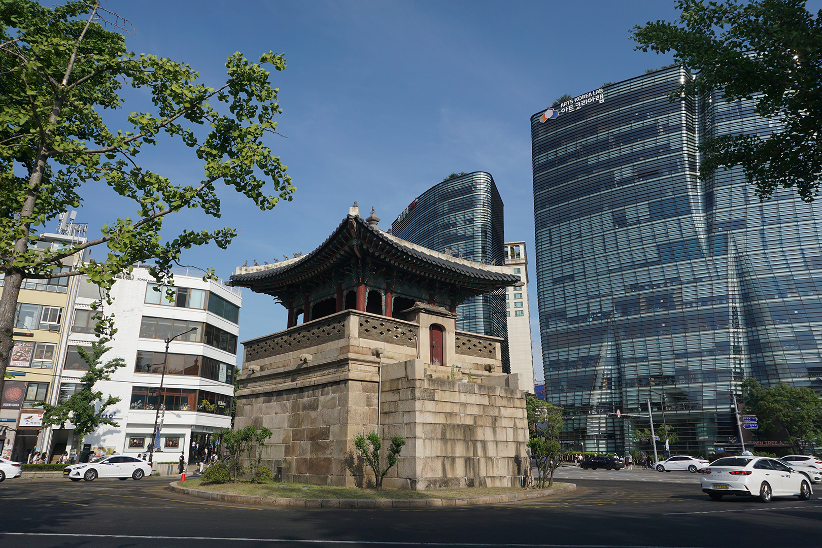 Korean historical watchtower with modern skyscrapers behind it