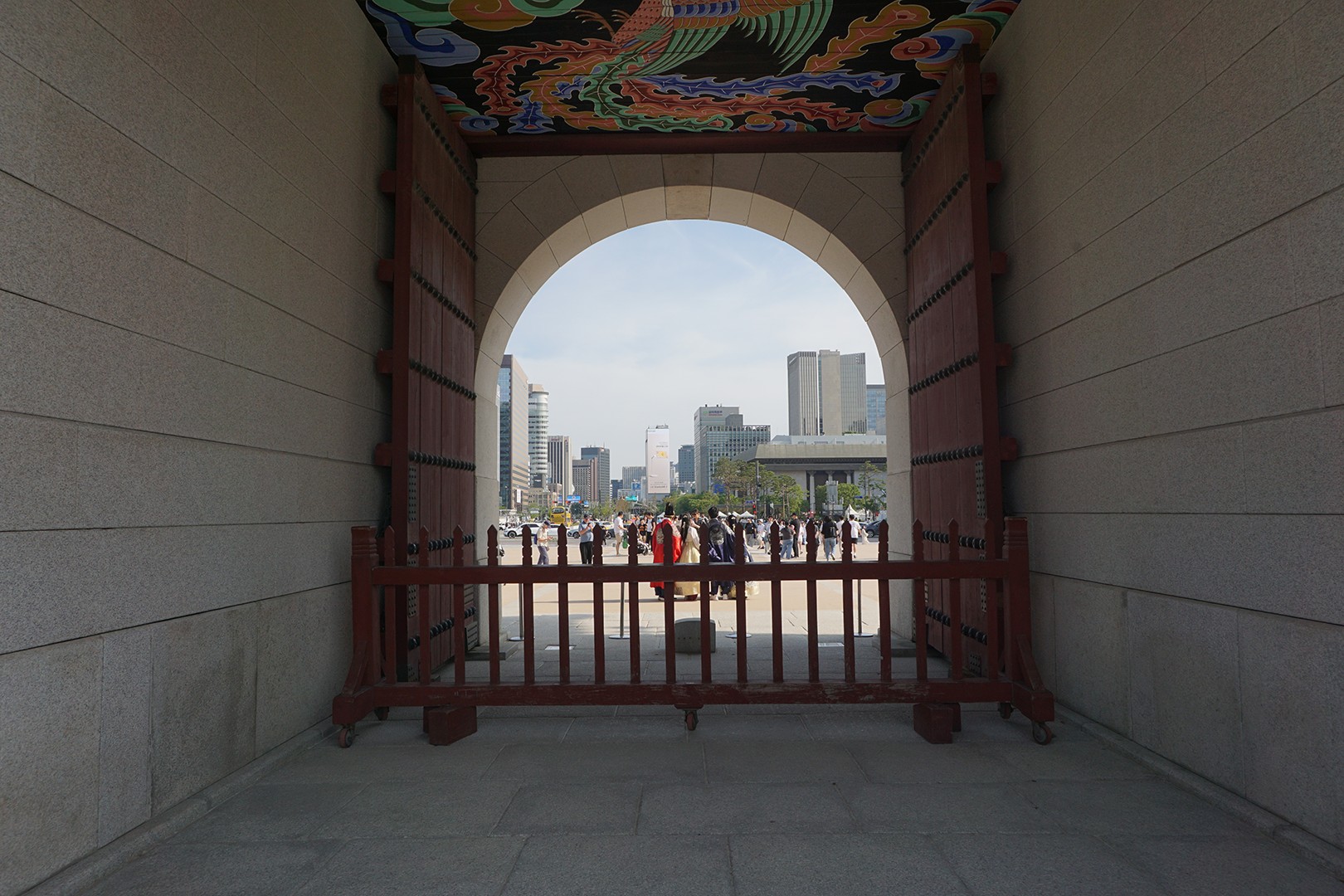 Peering through an ancient gate with the modern city spreading out in the distance