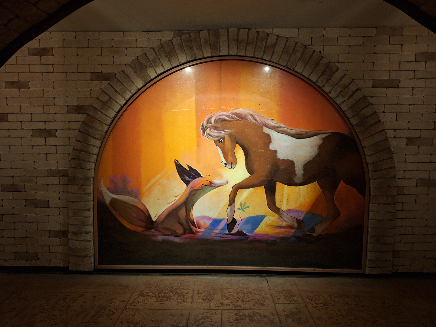 A painting with a horse and fox happily looking at each other