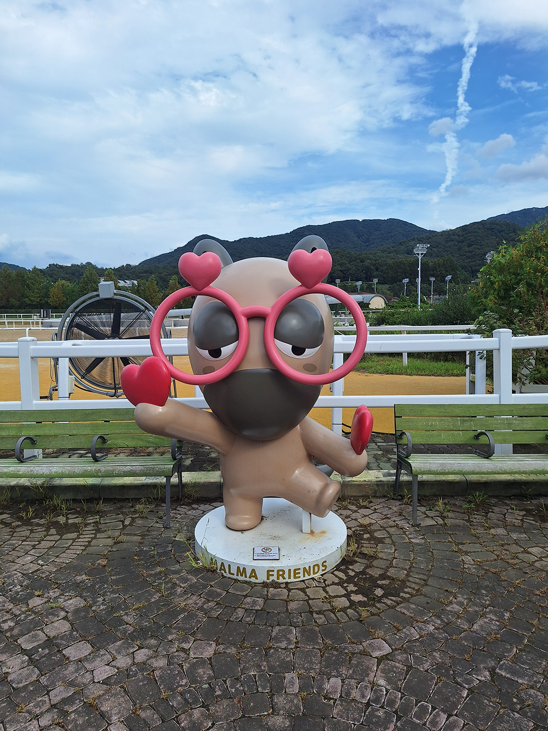 Malma with glasses holding hearts in his hand