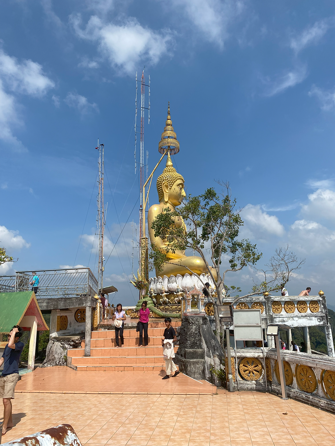 The top of the mountain showing the balcony and small structures as well as a side-view of a giant sitting Buddha