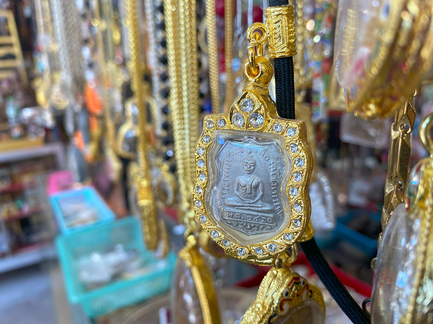 Thai amulets hanging above a seller's table.